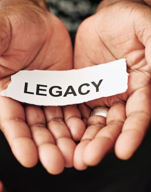 Cropped shot of a woman holding a piece of paper with the word “legacy” on it